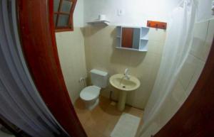 a small bathroom with a toilet and a sink at Country Inn, Suites & Condo in São Pedro da Serra