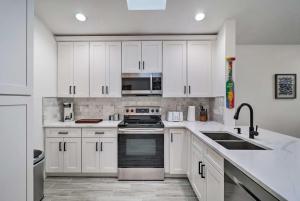 a white kitchen with white cabinets and appliances at Casa Azul Modern Ponte Vedra Beach Bungalow in Ponte Vedra Beach