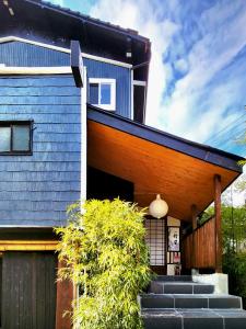 een huis met een blauw dak en een trap aan de voorkant bij 旅館 竹屋 Takeya in Yufu