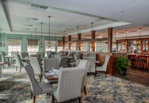 un restaurant avec des chaises et des tables ainsi qu'un bar dans l'établissement Oaks on the River, à Darien