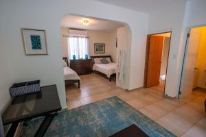 a living room with a couch and a bed in a room at Casa Verde Hotel in Rincon