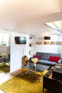 een woonkamer met een bank en een tafel bij Haut MaraisJolie duplex 33m2… in Parijs
