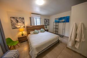 1 dormitorio con 1 cama y 1 silla verde en Casa Verde Hotel, en Rincón