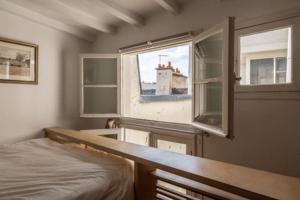 een slaapkamer met een bed en een raam bij Haut MaraisJolie duplex 33m2… in Parijs