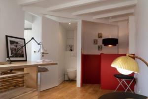 een kamer met een bureau en een rode muur bij Haut MaraisJolie duplex 33m2… in Parijs