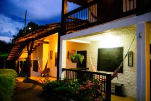 a house with a balcony with a tv on the side at Finca Hotel Loma Verde in Quimbaya