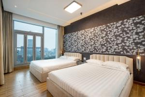 Cette chambre comprend 2 lits et une fresque murale. dans l'établissement Spacious Central Apartments for Group and Family - Sailing Tower, à Hô-Chi-Minh-Ville