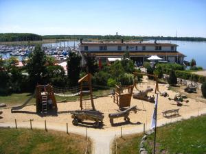 einen Spielplatz in einem Park neben einem Yachthafen in der Unterkunft Ferienwohnungen im Hafen Pier1 am Cospudener See bei Leipzig in Markkleeberg