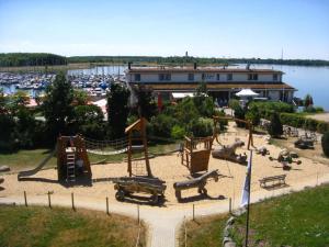 a playground in a park next to a marina at Ferienwohnungen im Hafen Pier1 am Cospudener See bei Leipzig in Markkleeberg