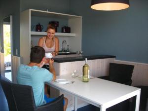een man en vrouw aan een tafel in een keuken bij Ferienwohnungen im Hafen Pier1 am Cospudener See bei Leipzig in Markkleeberg
