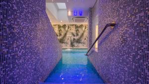 een paarse badkamer met een dompelbad met paarse tegels bij HOTEL CENTER 2 in Rome