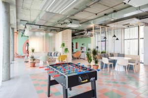 an office with a foosball table in the middle of a room at SHED Vilnius Coliving in Vilnius