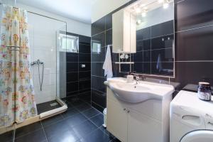 uma casa de banho com um lavatório e um chuveiro em Rooms Plaža Divuje em Murvica