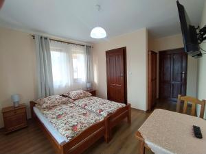 um quarto com uma cama e uma mesa em Pokoje Gościnne Waluś em Murzasichle