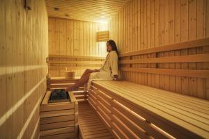 a woman sitting on the edge of a sauna at Hotel Vrata Krke in Lozovac