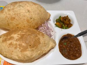 a plate of food with a burrito and a dipping sauce at Manu Villa-A Luxury Stay in Manali in Manāli