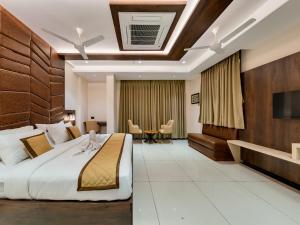 a hotel room with a bed and a table at Golden Leaf Resort in Dhule