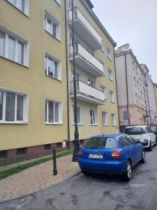 a blue car parked in a parking lot next to a building at Apartament Wschodnia in Lublin