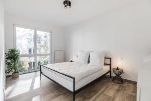 a white bedroom with a bed and a window at JAMA - Stilvoll&Modern, Zentral, Uni, Freies Parken, Große Gruppen, WLAN in Erlangen