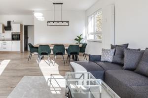 ein Wohnzimmer mit einem Sofa und einem Tisch in der Unterkunft JAMA - Stilvoll&Modern, Zentral, Uni, Freies Parken, Große Gruppen, WLAN in Erlangen