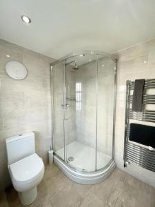 uma casa de banho com uma cabina de duche em vidro e um WC. em Richmond House (9A) by Staytor Accommodation em Exeter