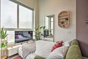 a bedroom with a couch and a large window at Stylish Ballard studio 15 mins from Space Needle in Seattle