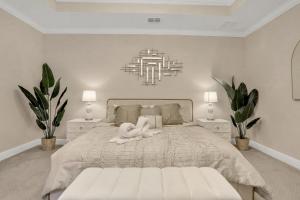 um quarto com uma cama branca com uma pessoa deitada sobre ela em Newport Retreat em Tampa