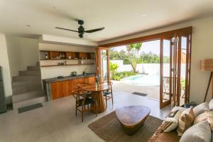 an open kitchen and living room with a table at Shoreline Villas Bingin in Uluwatu
