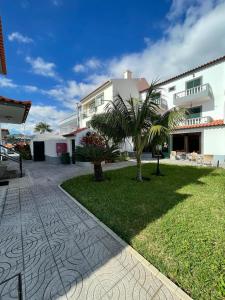 a large white building with a palm tree in the yard at Valhalla Panorama - the old Residencial Pina in Funchal