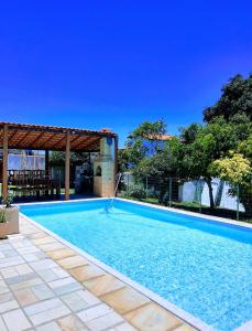 una gran piscina con una valla alrededor en Buganville House Cabo Frio en Río de Janeiro