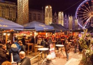 uma multidão de pessoas sentadas a mesas numa cidade à noite em Marshmallow em Liège