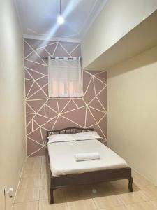 um pequeno quarto com uma cama com uma parede acentuada em Le Vert Homes em Kampala