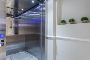 a glass shower in a room with potted plants at Cleveland Residences Farringdon in London