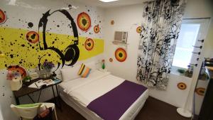 - une chambre avec un lit et une peinture murale dans l'établissement Rabbit芮比特, à Kenting