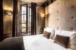 a bedroom with a large white bed with a window at Eiffel Trocadéro in Paris