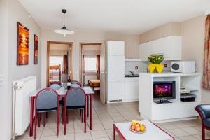 uma cozinha e sala de estar com mesa e cadeiras em Park Merlo em Bredene