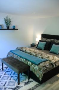 a bedroom with a bed with a bench on it at Apartman Kateřinky Liberec in Liberec