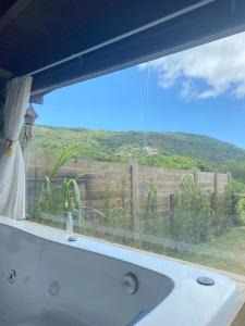 ventana de baño con bañera y vistas a una valla en Recanto Aloha Kaii, en Palhoça