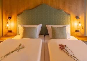 two beds in a room with flowers on them at Hotel Kammweg in Grossbreitenbach