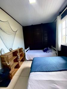 1 dormitorio con 2 camas y ventana en Recanto Aloha Kaii, en Palhoça