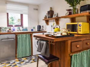 a kitchen with a wooden counter top and a microwave at Beeton Cottage Todmorden in Eastwood