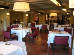 a dining room with white tables and red chairs at Hotel Argi Eder in Ainhoa