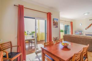 a living room with a table and a dining room at Vila Bela Nova Acácias 22 in Luz
