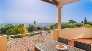 a balcony with a table and chairs and the ocean at Vila Bela Nova Acácias 22 in Luz