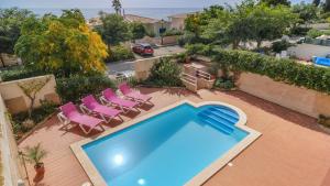 an overhead view of a swimming pool with pink chairs at Vila Bela Nova Acácias 22 in Luz