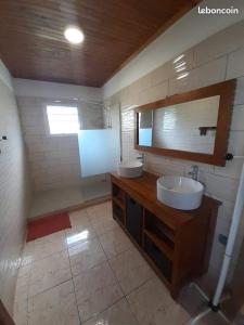 a bathroom with two sinks and a mirror at Villa Alcide in Rivière