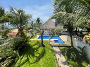 an aerial view of a resort with a swimming pool and palm trees at Casa Los Cocos Monterrico in Monterrico