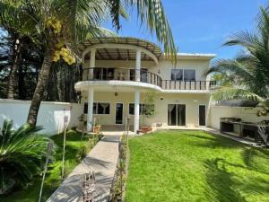 una gran casa blanca con un gran patio en Casa Los Cocos Monterrico, en Monterrico