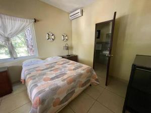a bedroom with a bed and a window and a door at Casa Los Cocos Monterrico in Monterrico