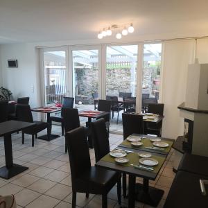 un ristorante sala da pranzo con tavoli e sedie e una grande finestra di Haus Hillebrand a Bad Honnef am Rhein